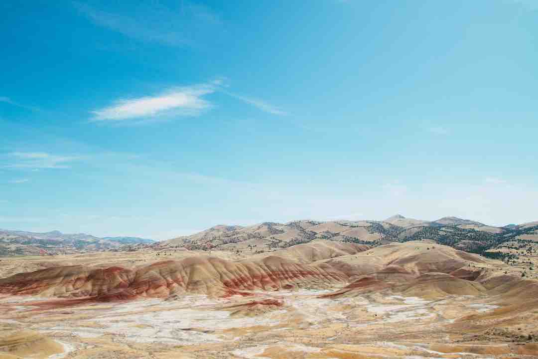 A high angle shot of the sandy hills in a deserted area under the bright sky